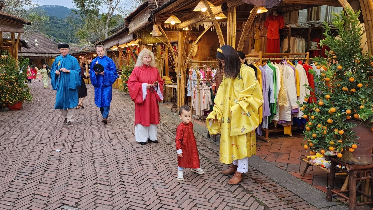 Đai gia đình khách du lịch nước ngoài trải nghiệm với trang phục áo dài truyển thống