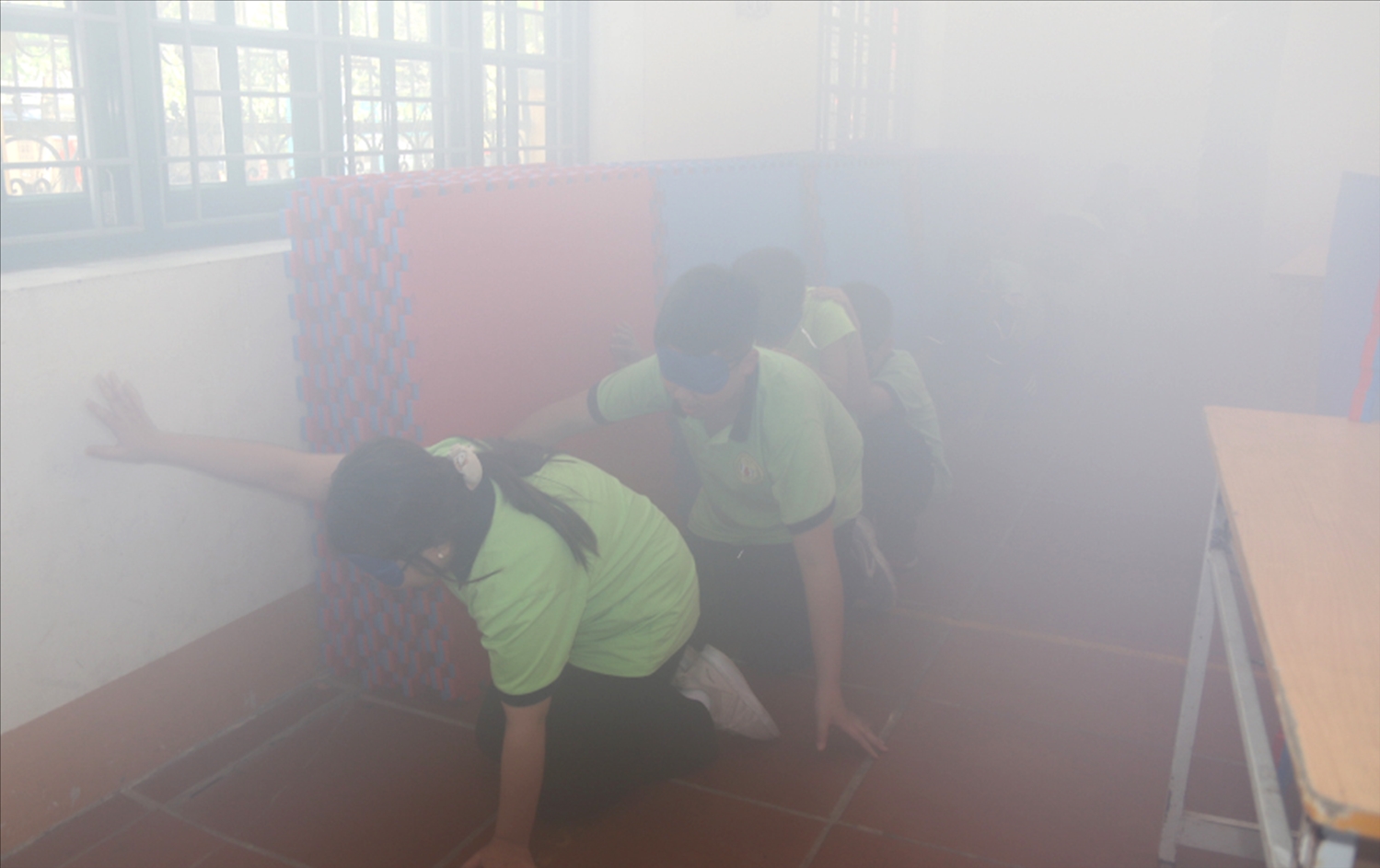 Các em học sinh được thực hành kỹ năng thoát khỏi phòng khói