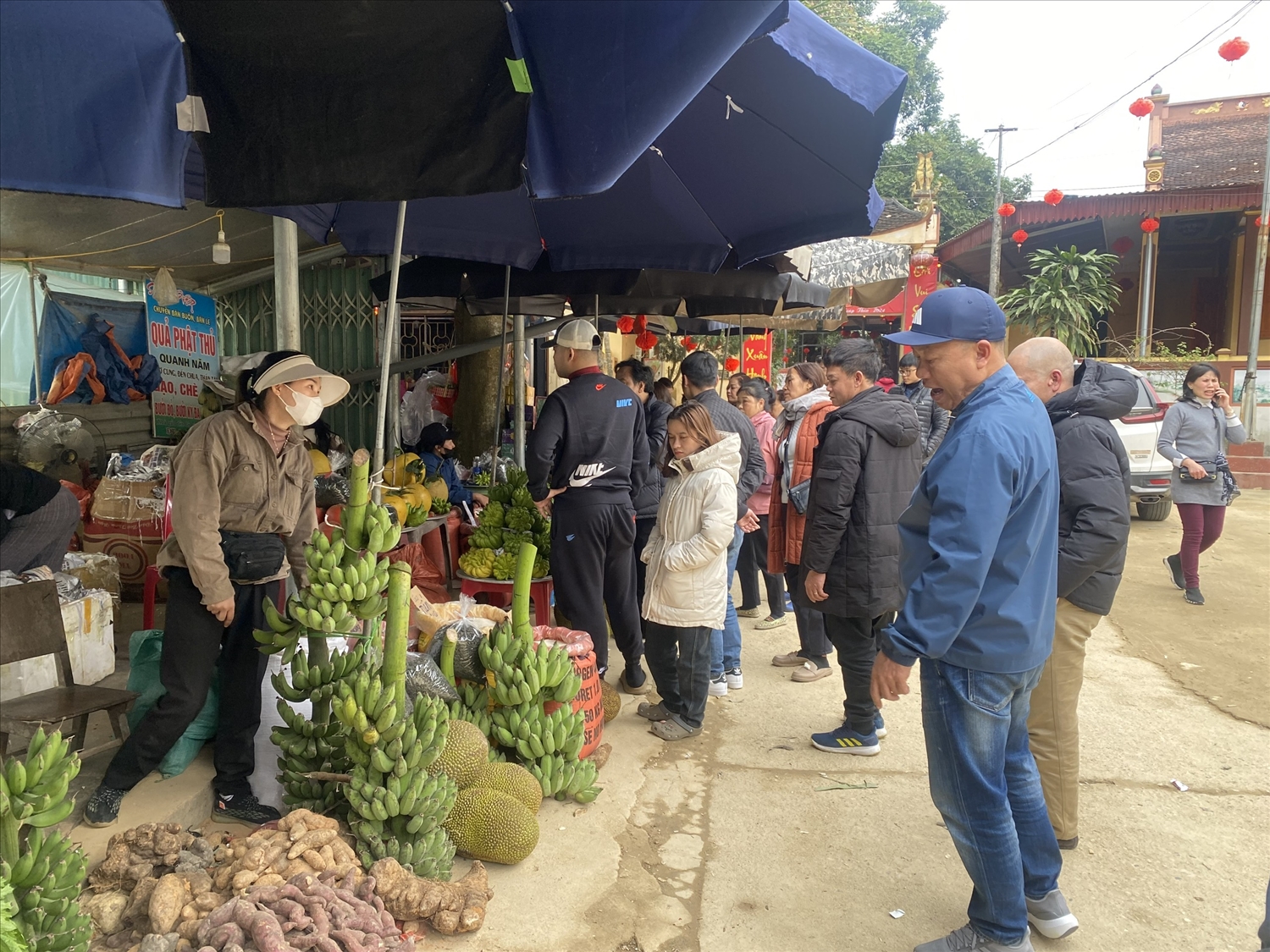 Phát triển du lịch góp phần tiêu thụ nông sản của địa phương. (Trong ảnh, khách du lịch thăm quan, mua sắm các sản vật địa phương tại đền Minh Lương, xã Lang Quán)