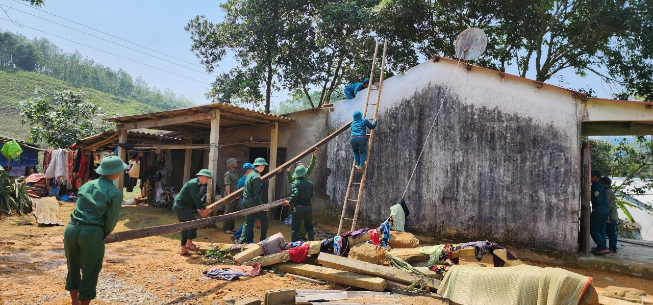 Cán bộ, chiến sĩ Đồn Biên phòng Hương Nguyên và chính quyền địa phương hỗ trợ các gia đình lợp lại mái nhà