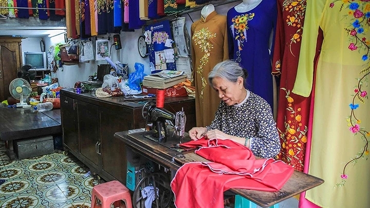 Bà Lê Thị Quyến, chủ hiệu áo dài Vinh Trạch, dù tuổi cao vẫn quyết tâm giữ nghề cho quê hương