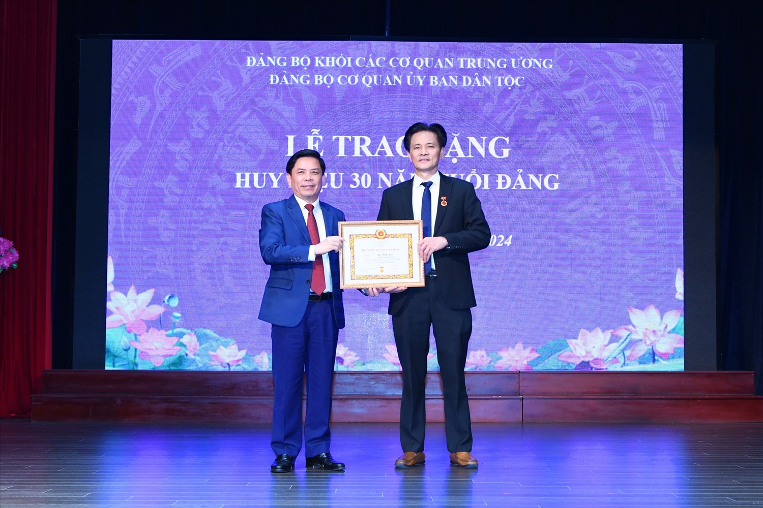 Bí thư Đảng ủy Khối các cơ quan Trung ương Nguyễn Văn Thể trao tặng Huy hiệu 30 năm tuổi Đảng cho Giám đốc Nhà khách Dân tộc Bùi Thiện Lạc
