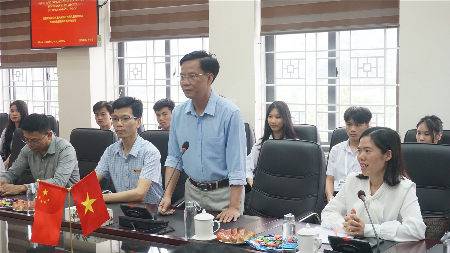 Hiệu trưởng Trường Cao đẳng Lào Cai Hoàng Quang Đạt báo cáo tình hình dạy và học tiếng Trung của trường với Đại sứ Hùng Ba