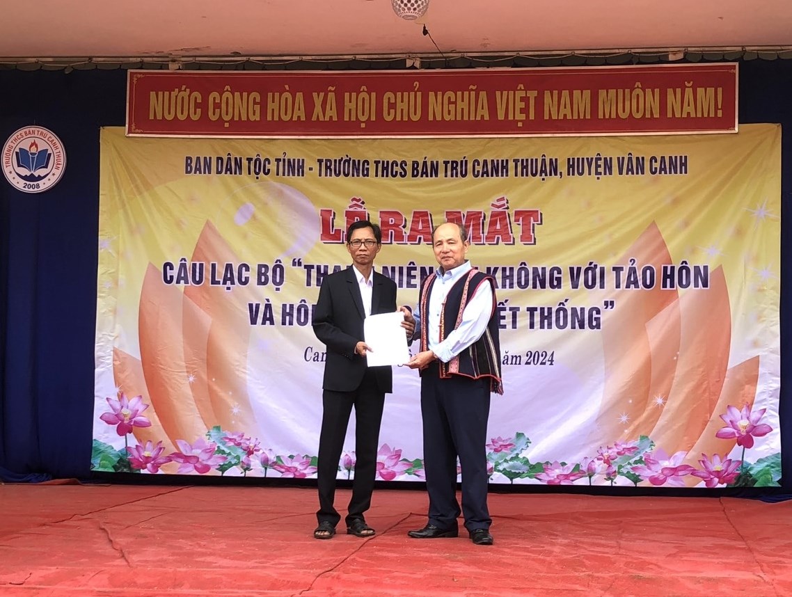 Thầy Trần Duy Khá (bên phải), Hiệu trưởng Trường THCS Bán trú Canh Thuận trao Quyết định thành lập CLB 