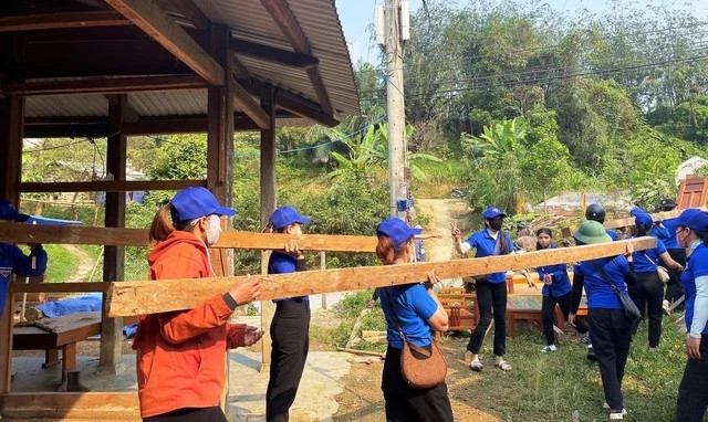 Các nữ đoàn viên hỗ trợ người dân di dời nhà, vật dụng dưới cái nắng gay gắt ở huyện vùng biên Nam Giang