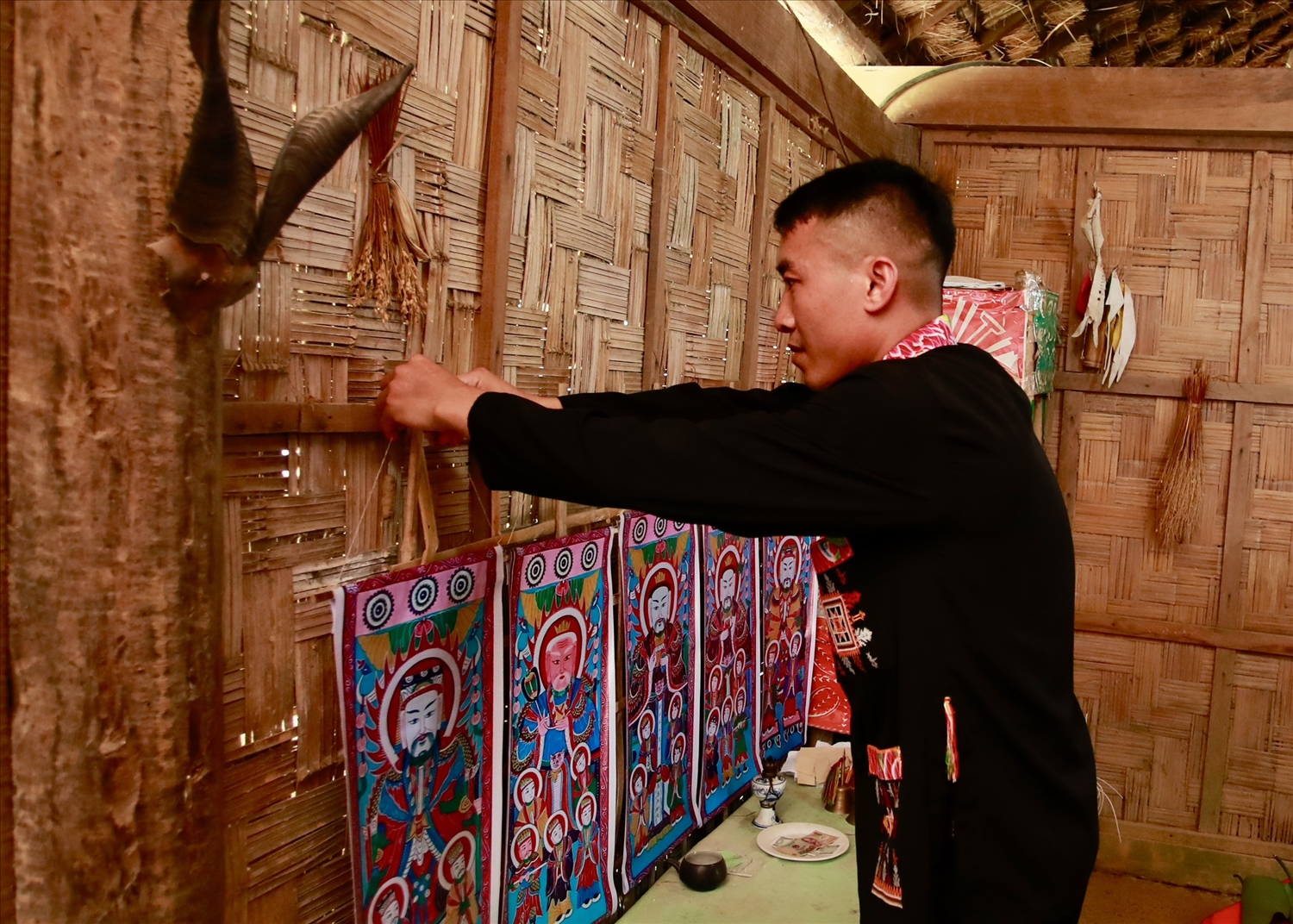 Treo tranh thờ chuẩn bị nghi lễ "đặt tên âm và lên đèn" trong lễ Cấp sắc của đồng bào Dao