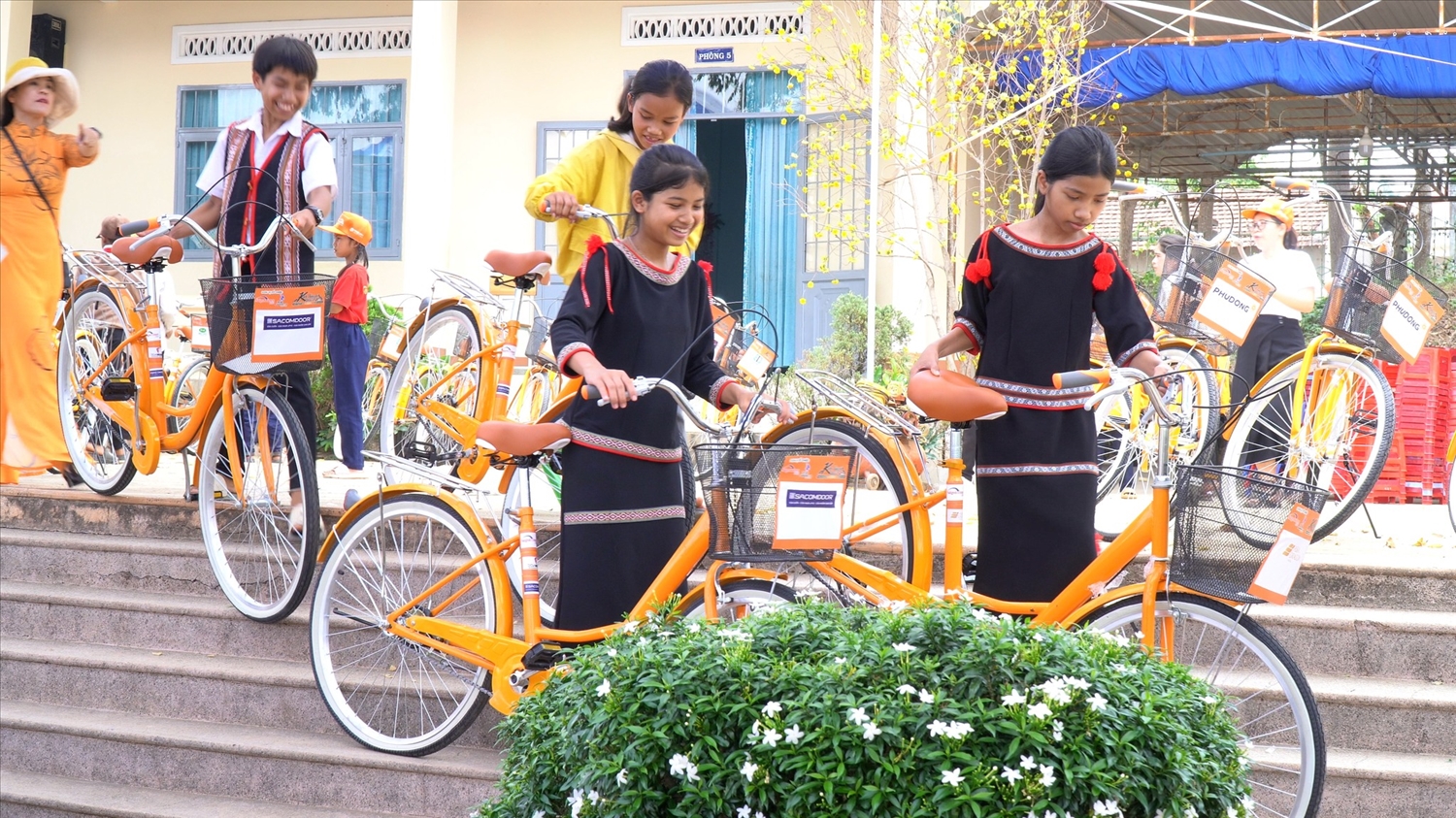 Các em học sinh DTTS xã Ngọk Réo vui mừng khi được nhận xe đạp do Câu lạc bộ Doanh nhân 2030 trao tặng