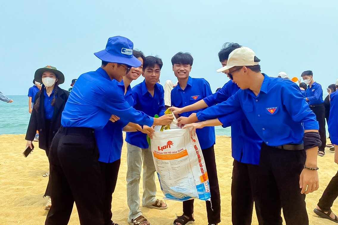 Các em học sinh tham gia dọn vệ sinh tại bãi biển Hàm Rồng, xã Vinh Hiền, huyện Phú Lộc, tỉnh Thừa Thiên Huế