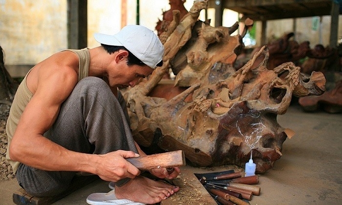 Nghệ nhân Làng mộc Kim Bồng chế tác sản phẩm đồ gỗ mỹ nghệ. Ảnh: TL