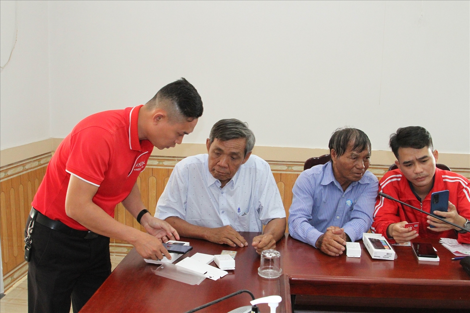 Nhân viên kỹ thuật Viettel hướng dẫn Người có uy tín huyện Ninh Phước sử dụng điện thoại thông minh được trao tặng.