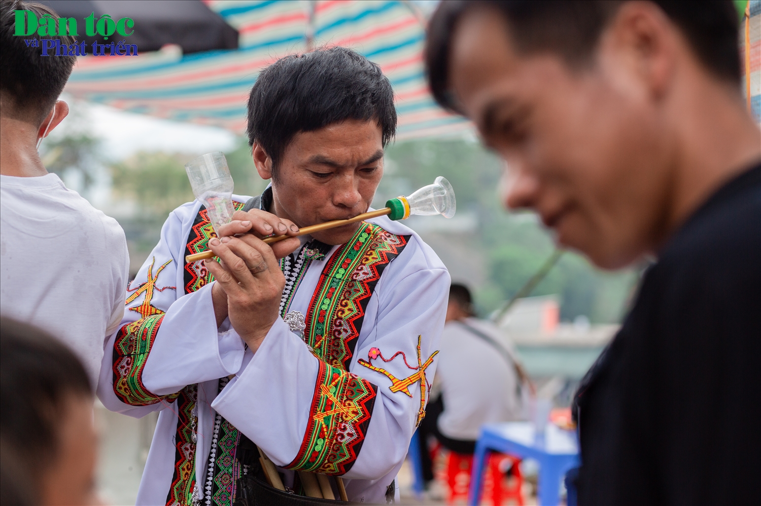 Người đàn ông dân tộc Mông say đắm trong tiếng sáo tại phiên chợ. 