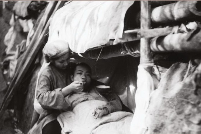 Nữ hộ lý tận tình bón từng thìa cháo cho thương binh ngoài hỏa tuyến Điện Biên Phủ năm 1954.
