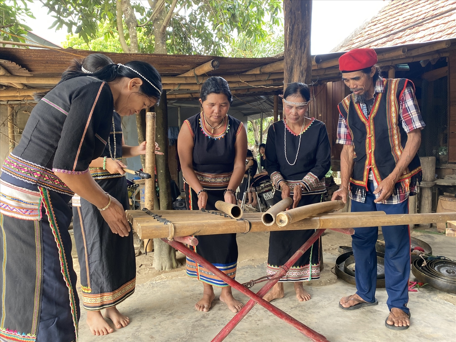 Nghệ nhân ưu tú A Thuih (ngoài cùng bên phải) hướng dẫn người dân trong làng trình diễn nhạc cụ truyền thống của dân tộc