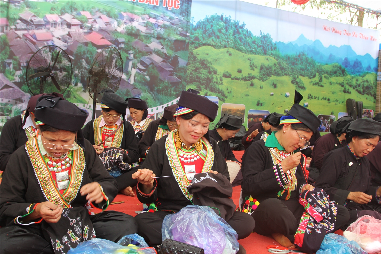 Các chị em phụ nữ thêu trang phục dân tộc tại ngày hội
