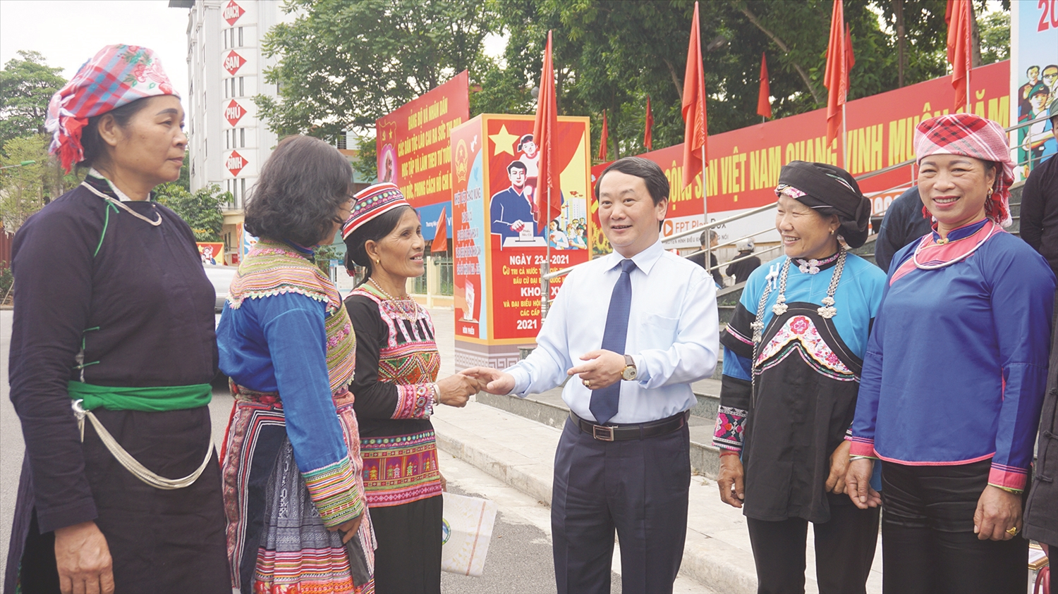 Bộ trưởng, Chủ nhiệm UBDT Hầu A Lềnh trò chuyện với đại biểu là Người có uy tín tỉnh Lào Cai nhân Hội nghị biểu dương Người có uy tín và người DTTS tiêu biểu tỉnh Lào Cai năm 2021