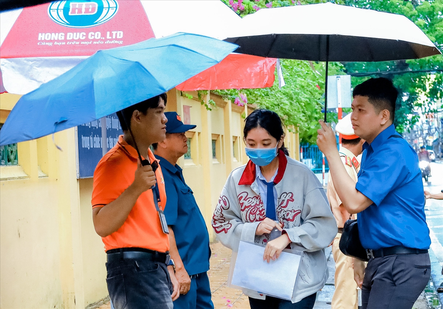Sáng nay TP Cần Thơ có mưa nhỏ, các thí sinh đến điểm thi Trường THPT Châu Văn Liêm, quận Ninh Kiều được các tình nguyện viên tiếp sức mùa thi hỗ trợ che ô từ ngoài cổng để vào điểm th