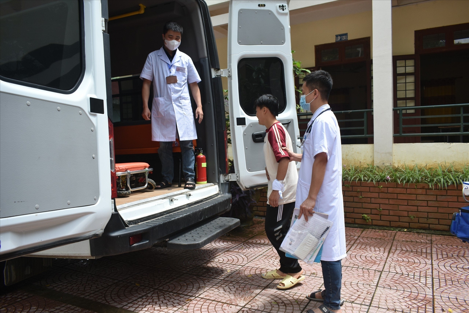 Em Hoàng Thị Loan - Học sinh lớp 12a2 của Trường THPT Pắc Khuông được các nhân viên y tế hỗ trợ, đưa đón đến điểm thi