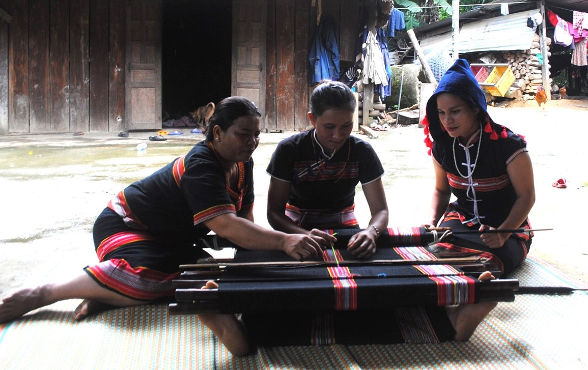 Zơ Râm Thị Thon (người ngồi giữa) được chị Kring Thị Viết tận tình truyền dạy nghề dệt thổ cẩm