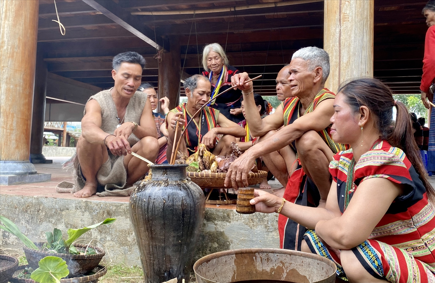 Già làng thực hiện nghi thức cúng trên ghè rượu mời thần linh về uống, chứng giám cho dân làng