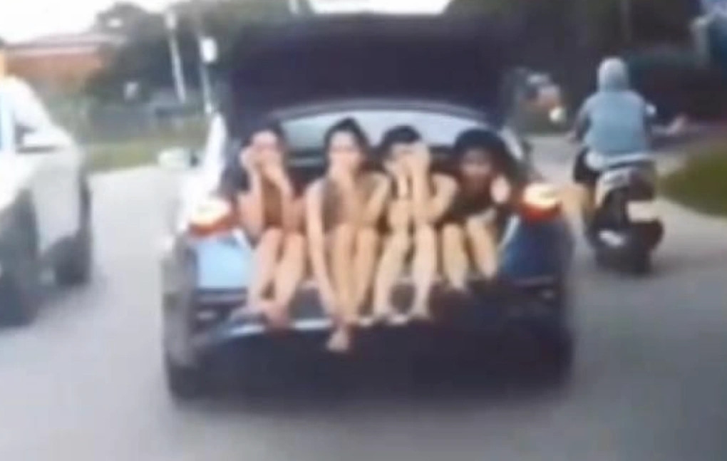 Chiếc xe chở 4 cô gái ngồi ở cốp. Ảnh chụp màn hình