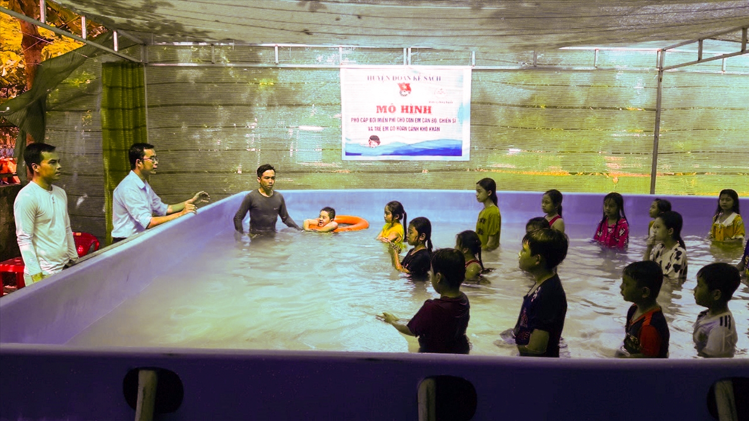 Lớp học bơi của thầy Tính (bìa trái) có khoảng trên dưới 30 em và gần 6 năm qua đã có hơn 1.000 em học sinh ở địa phương biết bơi. Ảnh: Trinh Trinh