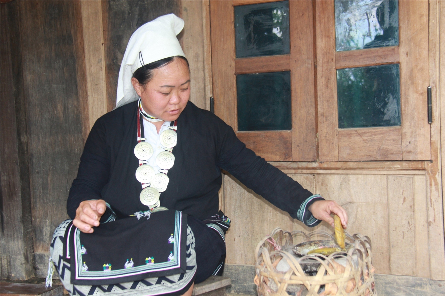 Chị Bàn Thị Liên đun nóng sáp ong trước khi in lên vải (Ảnh: Thành Luân)