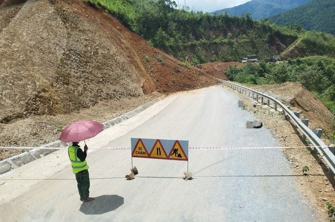 Đơn vị quản lý tuyến đường đã cử người chốt trực, căng dây, cắm biển báo hiệu. (Ảnh: TTXVN)