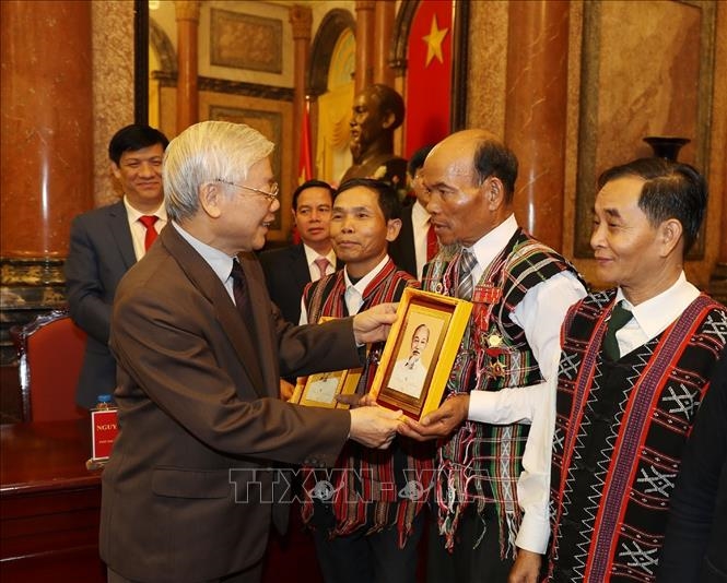 Tổng Bí thư, Chủ tịch nước Nguyễn Phú Trọng tặng quà lưu niệm cho các già làng, trưởng bản, trưởng dòng họ, người có uy tín tiêu biểu. (Ảnh Trí Dũng - TTXVN)