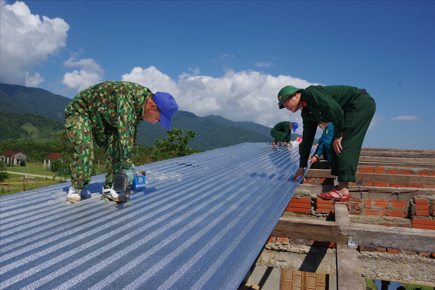 Cán bộ, nhân viên Đoàn 92 giúp bà con nhân dân lợp lại nhà ở do lốc xoáy gây ra.