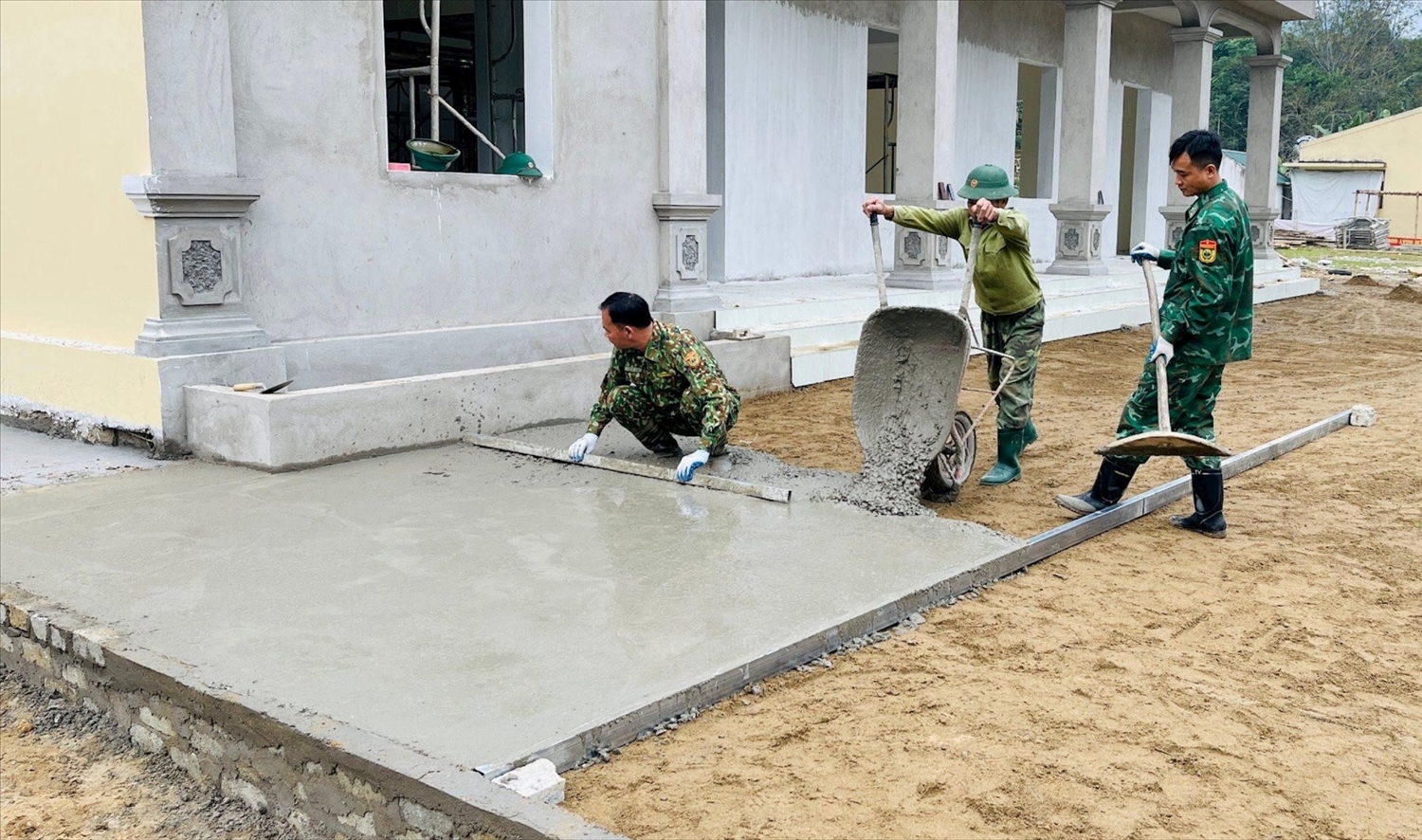 Tổ thợ xây Đồn Biên phòng Tam Quang hỗ trợ bản Tùng Hương đổ bê tông sân nhà văn hoá cộng đồng.