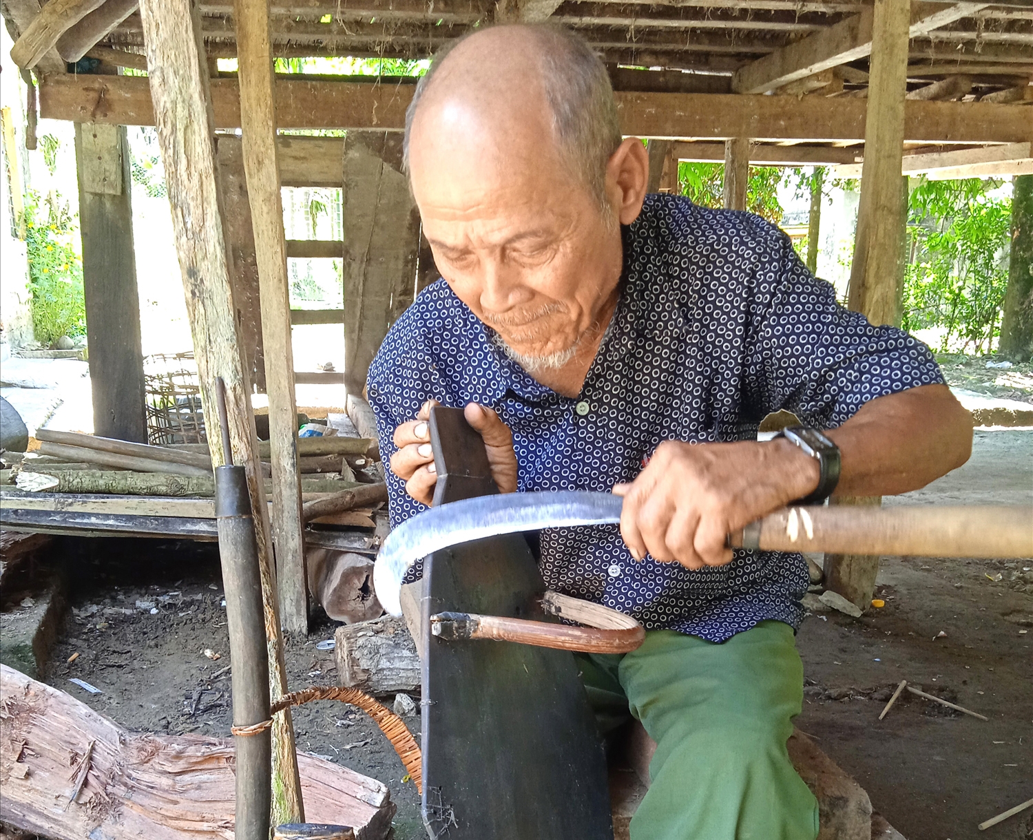 Già Đinh Văn An ở tại thôn 6, xã Trà Bui đang làm khiên.