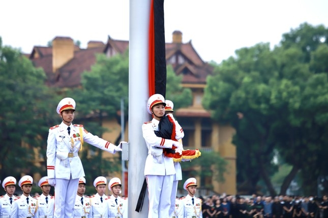 Lễ thượng cờ rủ được tiến hành trang nghiêm, tiêu binh không tung Quốc kỳ như thường lệ mà ôm trước ngực. (Ảnh: Tienphong.vn)