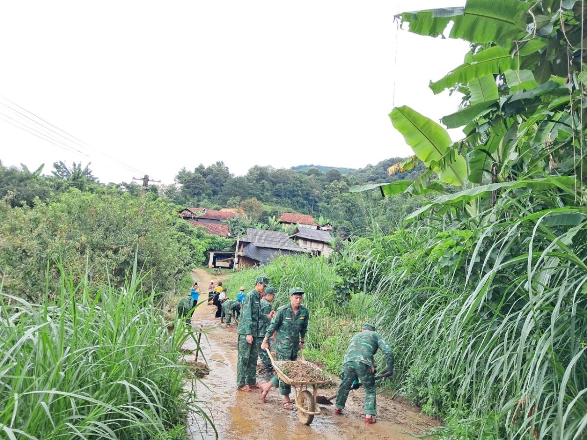 Cán bộ, chiến sĩ Đồn Biên phòng Chiềng On (BĐBP Sơn La) phối hợp cùng Nhân dân dọn bùn ở đất tại các con đường dân sinh sau mưa lũ. Ảnh: Vì Hiện.