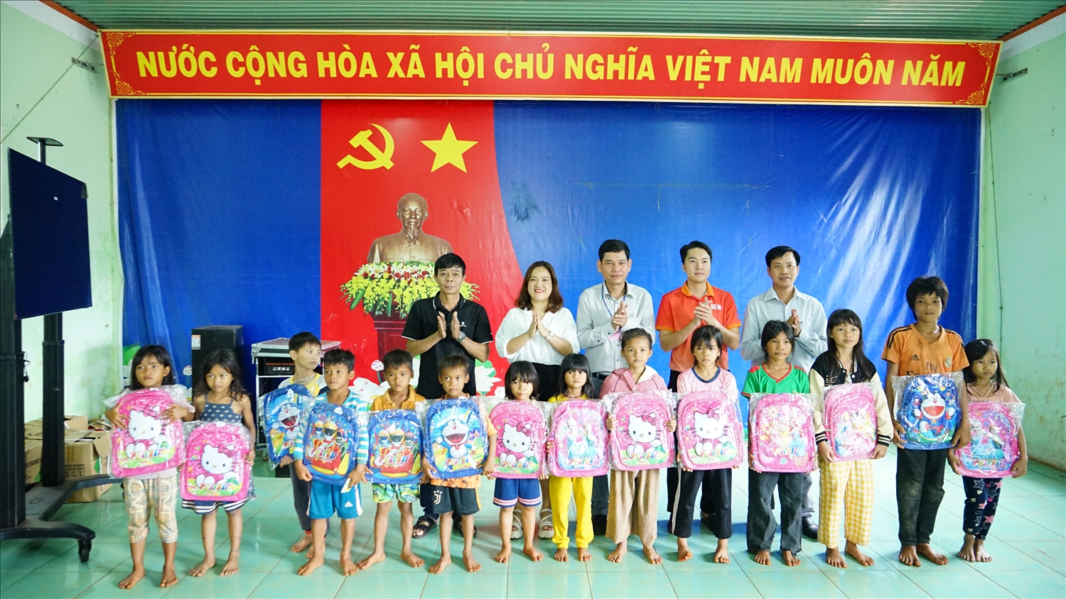 Các mạnh thường quân, lãnh đạo huyện Chư Pưh trao cặp sách cho các em học sinh vùng khó đến trường