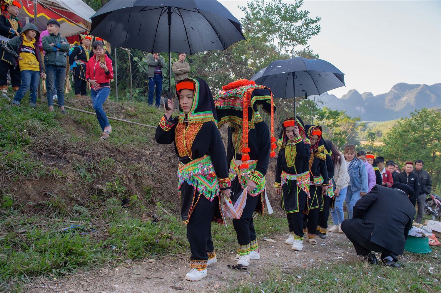 Đoàn nhà gái đang tiến về đoàn nhà trai. Cô dâu đi giữa được hai phù dâu che ô. Phù dâu cũng mặc áo chồng nhiều lớp nhưng không dày bằng áo của cô dâu.Theo tục lệ, chú rể Dao Lù Gang không đi đón dâu mà ở nhà chuẩn bị các nghi thức cúng.