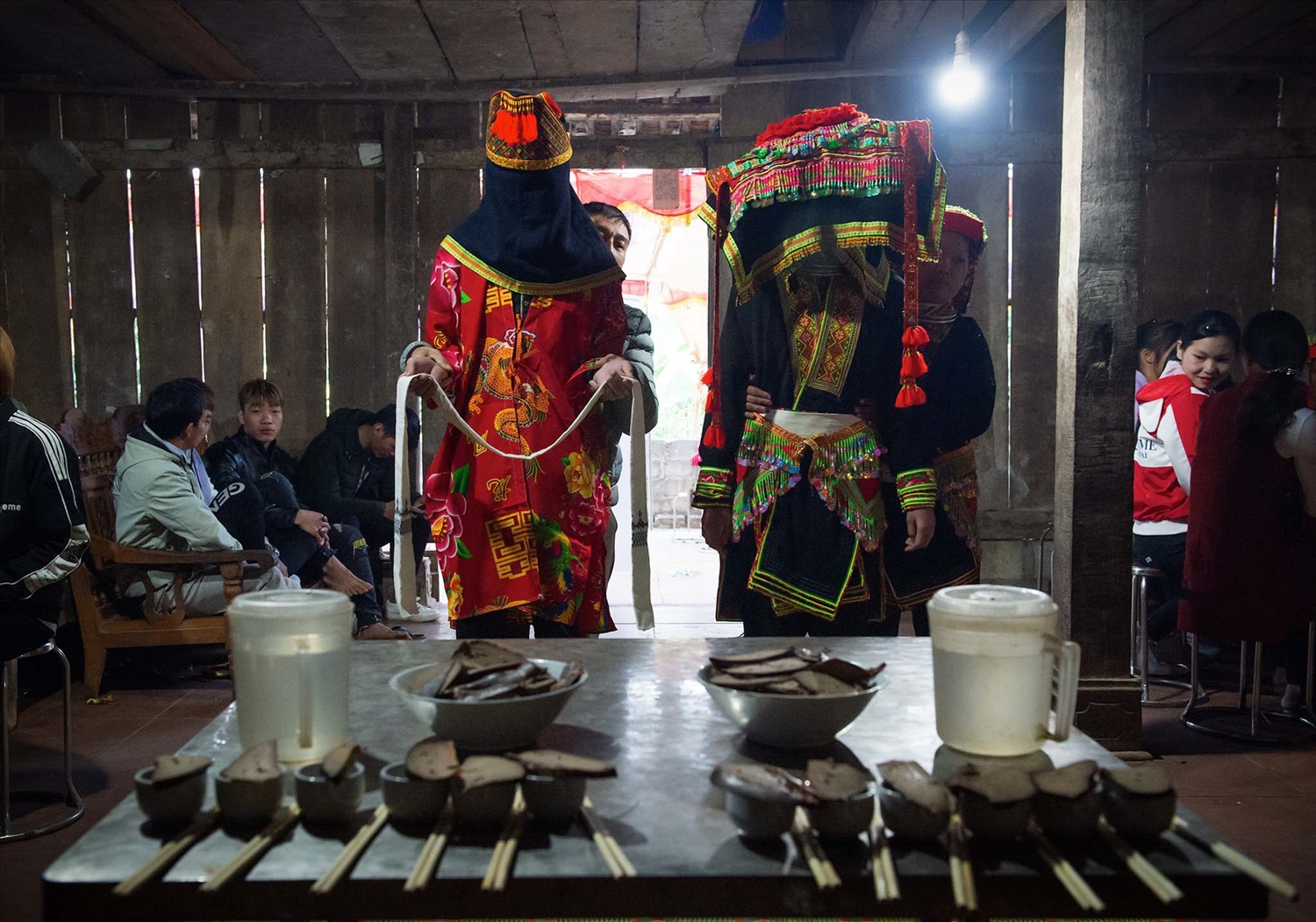 Trên bàn cúng lúc này bố trí 12 chiếc chén, 12 đôi đũa của thầy cúng và gia tiên, đặt bên trên miệng chén là miếng gan lợn nướng. Sau đó, cô dâu, chú rể rót rượu mời họ hàng hai bên.