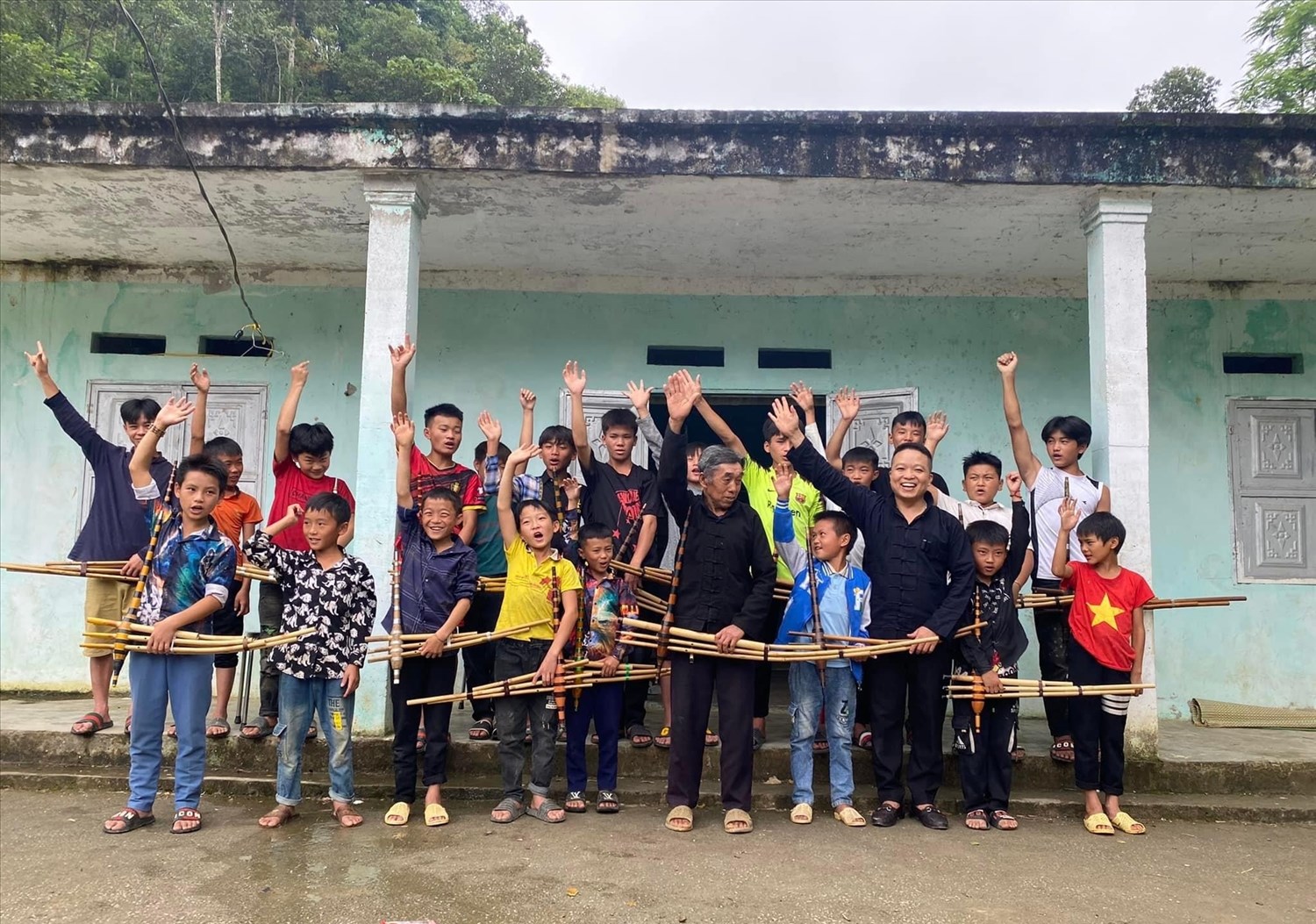 Chủ nhiệm CLB Sùng Minh Thành (người đứng thứ ba hàng đầu, bên phải sang trái) và nghệ nhân chụp hình sau buổi dạy múa, thổi khèn cho con em đồng bào dân tộc Mông ở địa phương.