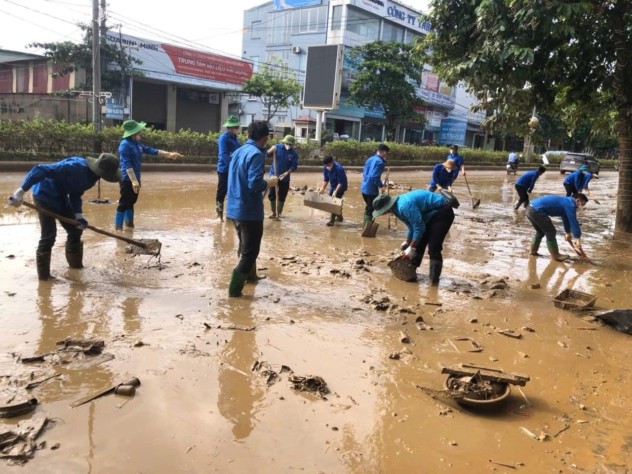 Các đoàn viên thanh niên tham gia dọn dẹp bùn đất trên các tuyến phố