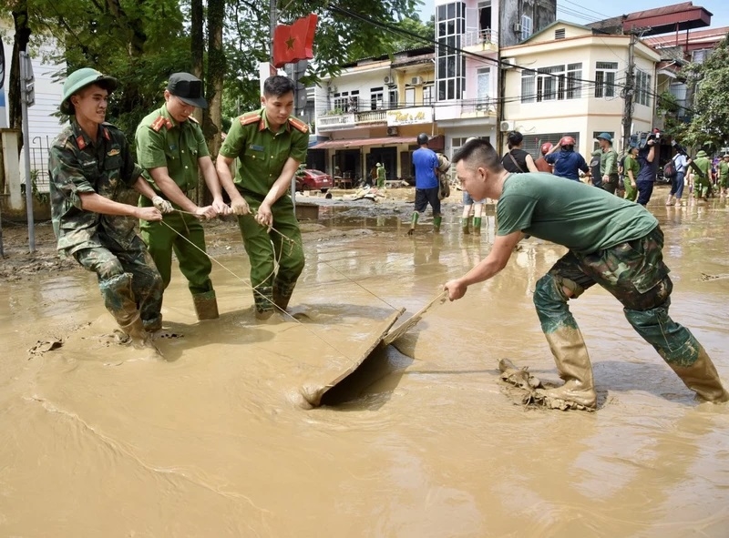 Các lực lượng quân đội và công an giúp nhân dân dọn dẹp vệ sinh môi trường sau bão lũ tại thành phố Yên Bái (Ảnh: Trần Hải)