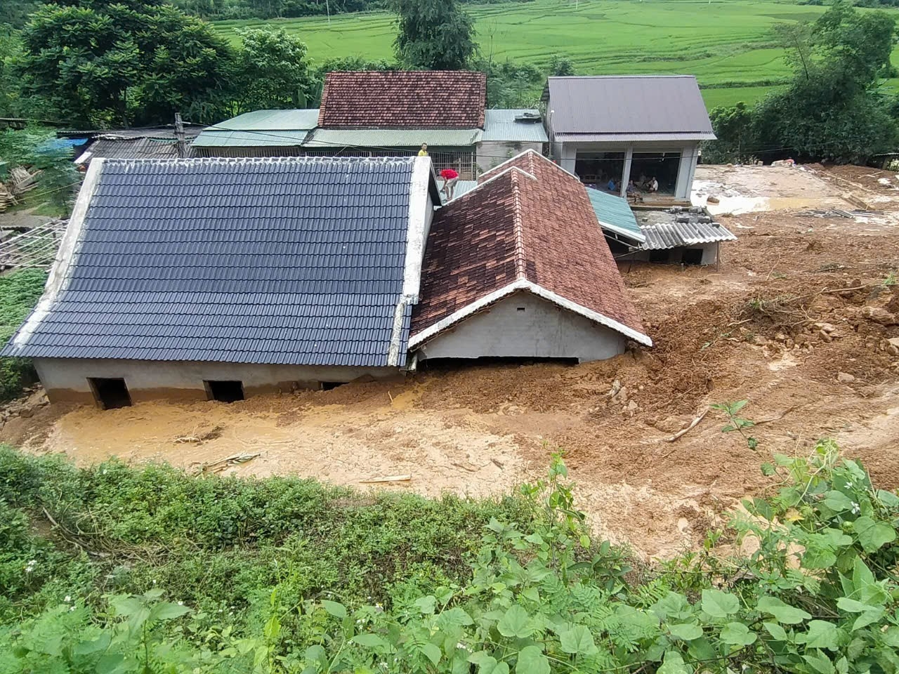 Hộ gia đình La Văn Ỏn ở bản Xiêng Thù, xã Chiêu Lưu (Kỳ Sơn) bùn đất từ núi sạt xuống ngập ngang mái nhà