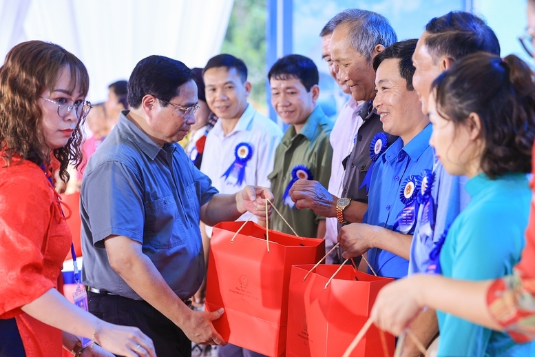 Thủ tướng Phạm Minh Chính tặng quà các đại biểu là bí thư chi bộ, trưởng thôn, già làng, trưởng bản, người có uy tín của huyện Đà Bắc - Ảnh: VGP/Nhật Bắc