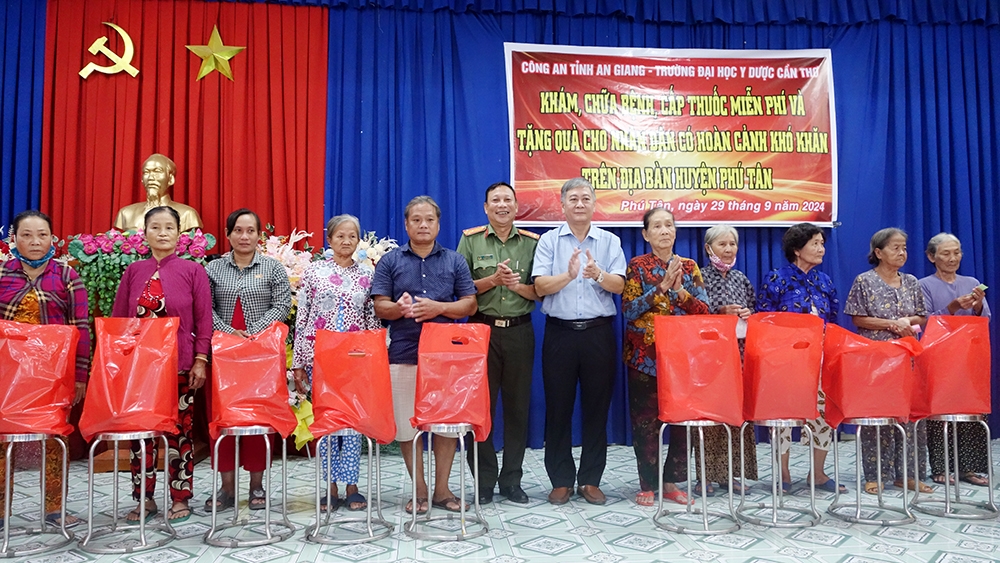 Đại diện Ban tổ chức trao quà cho người dân đến tham gia khám chữa bệnh tại huyện Tân Phú ( An Giang)