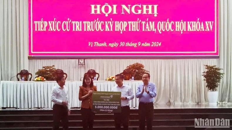 Chủ tịch Quốc hội Trần Thanh Mẫn chứng kiến Ngân hàng Vietcombank trao tượng trưng 5 tỷ đồng ủng hộ huyện Vị Thủy xây dựng giao thông nông thôn. (Ảnh: PHÙNG DŨNG)