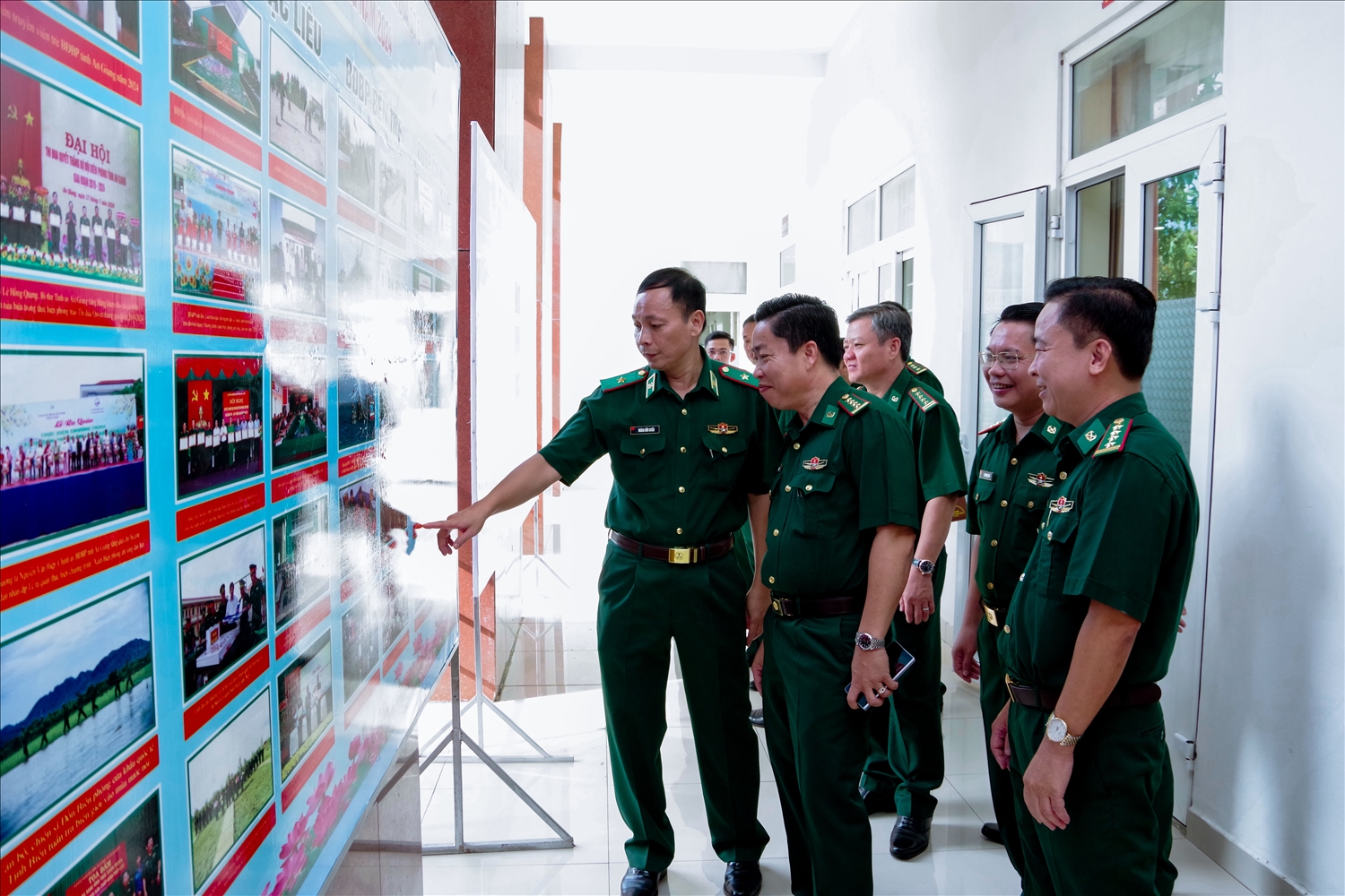 Thiếu tướng Hoàng Hữu Chiến và các đại biểu tham quan bảng ảnh chào mừng Hội nghị Cụm thi đua 