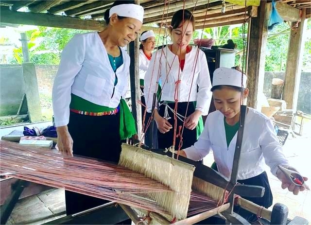 Nghệ nhân Phùng Thị Dổi truyền dạy nghề dệt thổ cẩm truyền thống của dân tộc cho các học viên tại xã Kim Thượng (Ảnh: PT - NVCC)