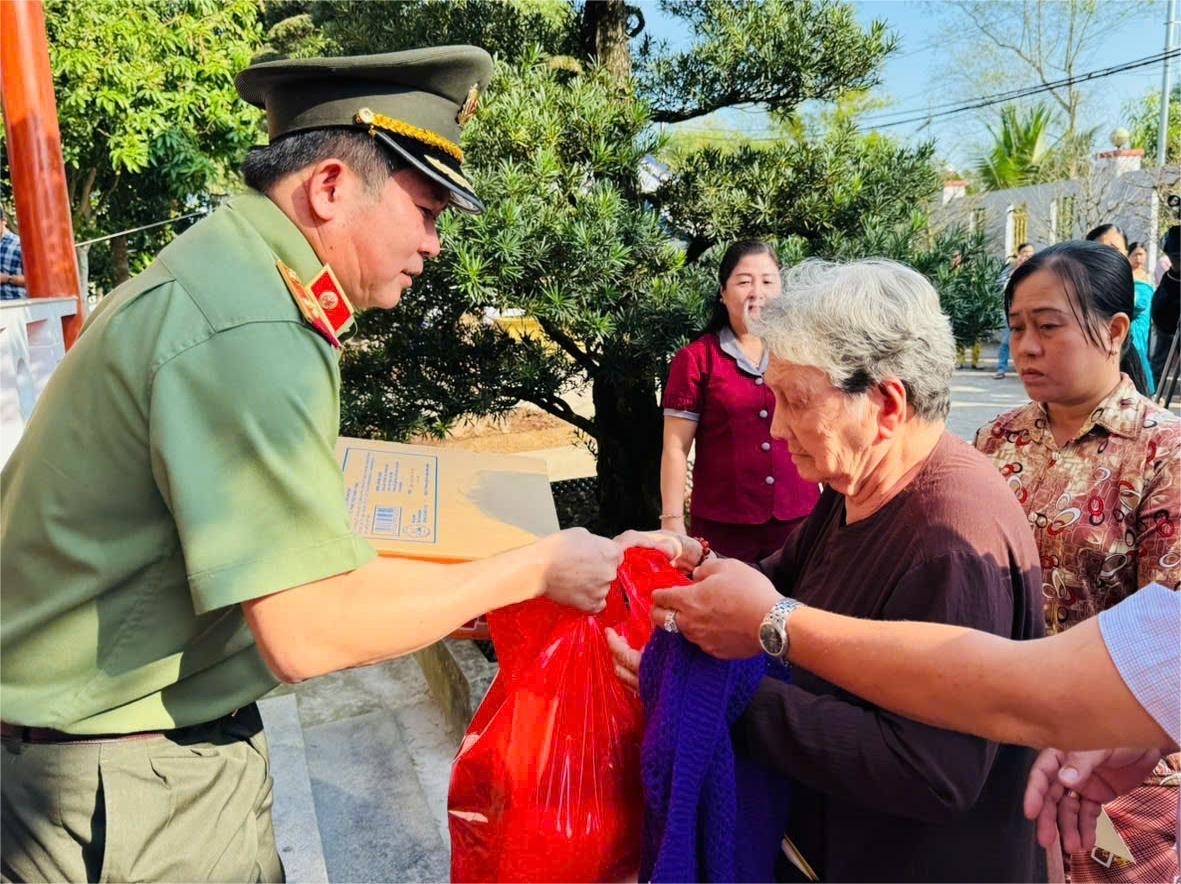 Thiếu tướng Đinh Văn Nơi trao quà và ân cần thăm hỏi bà con Nhân dân có hoàn cảnh khó khăn