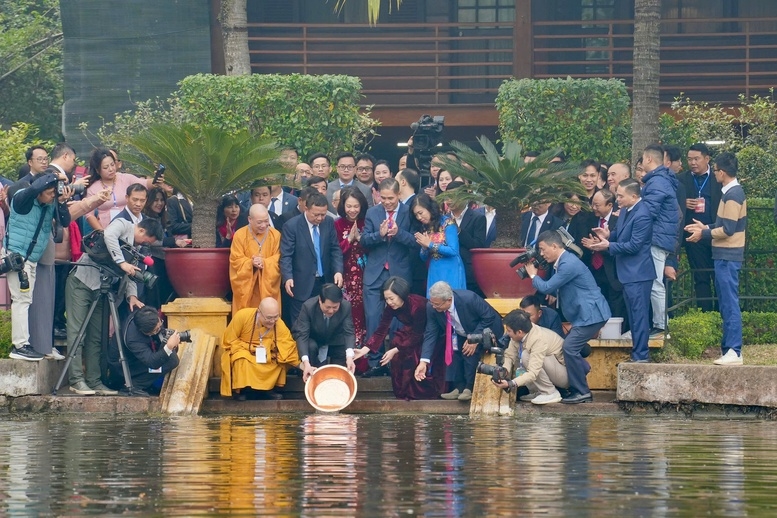 Chủ tịch nước và Phu nhân cùng kiều bào tham gia hoạt động phóng sinh cá chép tại Ao cá Bác Hồ trong khuôn viên Khu Di tích Chủ tịch Hồ Chí Minh tại Phủ Chủ tịch - Ảnh: VGP/Diệp Anh