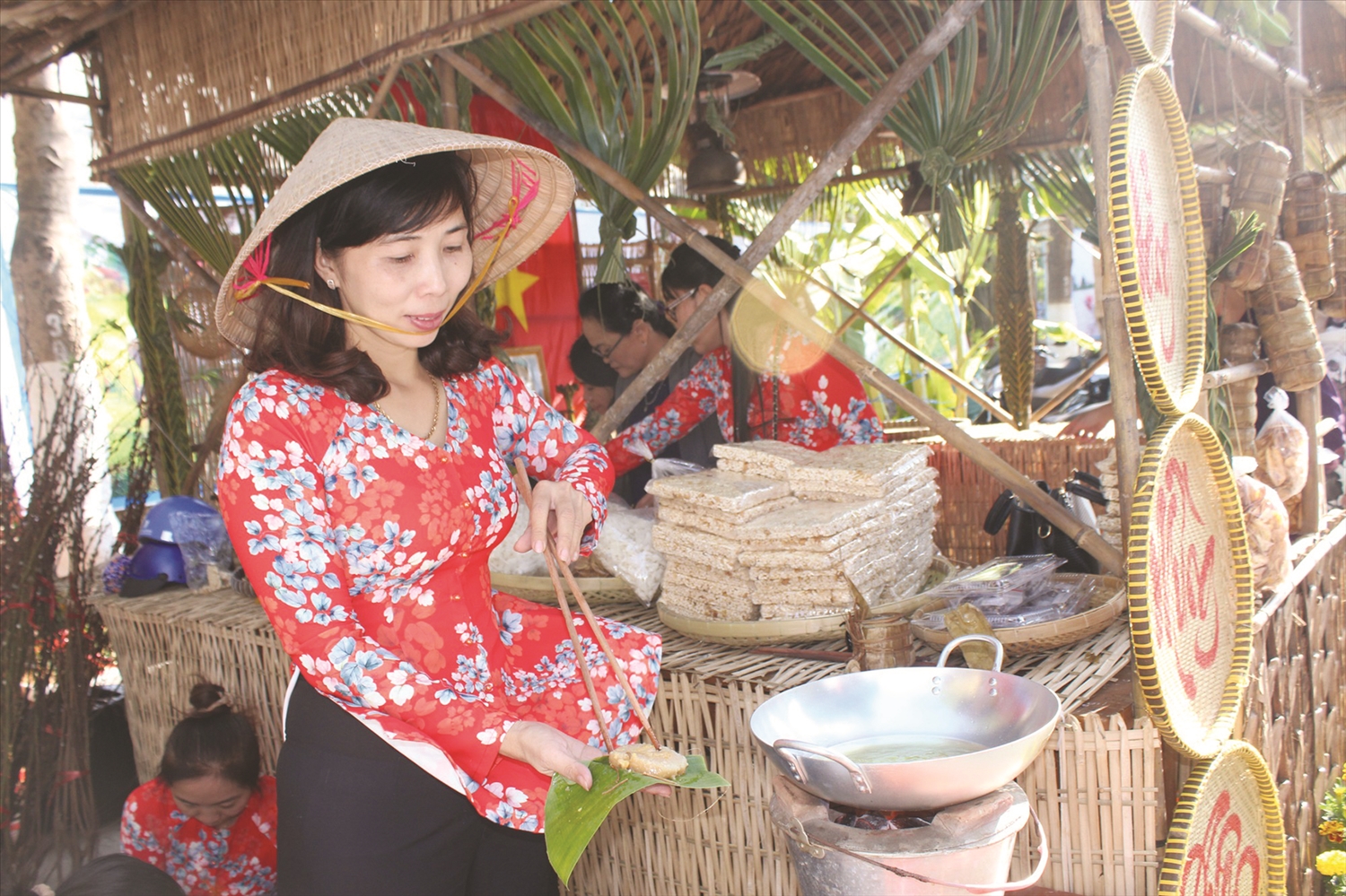 Một gian hàng đang chiên bánh tét để đãi du khách tham quan.