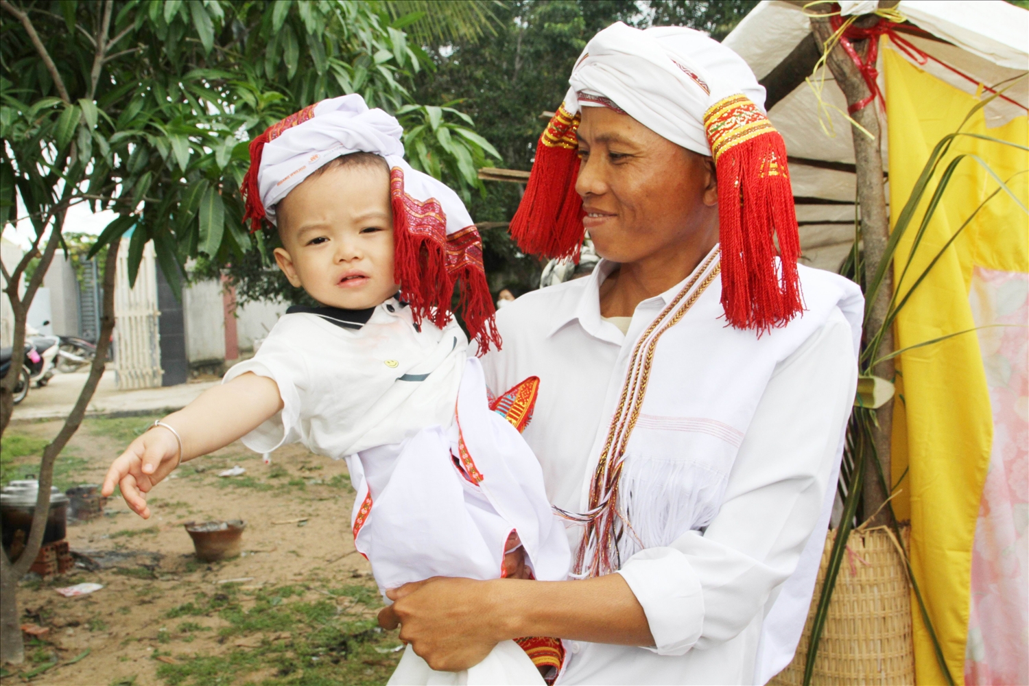 Anh Đạo Công Văn bế con trai Đạo Thế Bảo là “nhân vật” chứng kiến nghi Lễ trưởng thành cho các thiếu nữ.