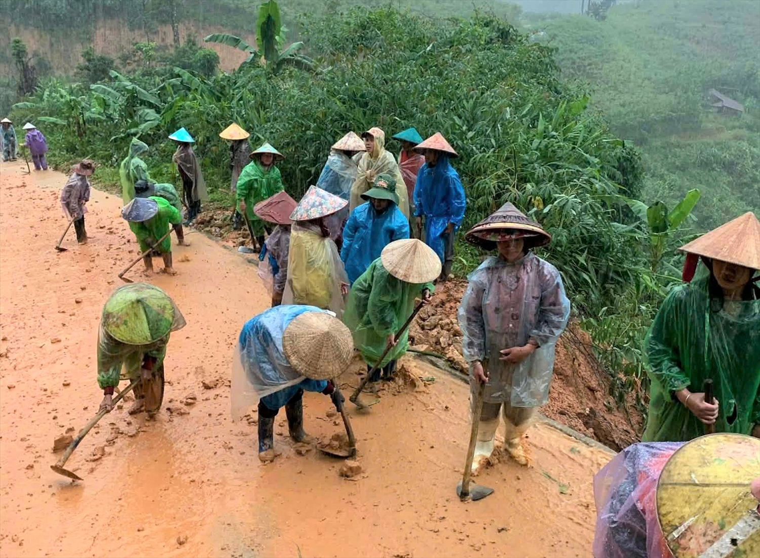 Phụ nữ và người lớn tuổi thì lo phần việc dọn dẹp bùn đất trên các tuyến đường liên thôn. (Ảnh: Ngọc Chí) Phụ nữ và người lớn tuổi thì lo phần việc dọn dẹp bùn đất trên các tuyến đường. (Ảnh: Ngọc Chí)